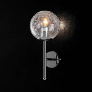 Modern wall lamp in polished chrome iron with transparent glass sphere